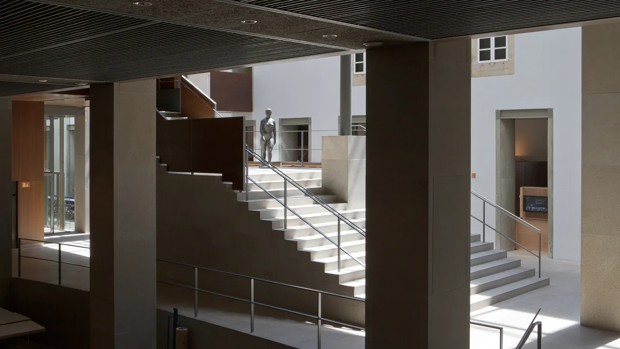 El vestíbulo del Museo de Belas Artes, con la escalera de piedra subiendo hacia una escultura y las puertas de las salas a los lados.