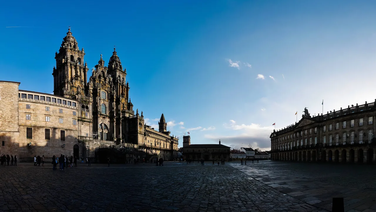 La Praza do Obradoiro casi vacía, con la fachada barroca de la catedral a la izquierda y el Pazo de Raxoi al fondo a la derecha.
