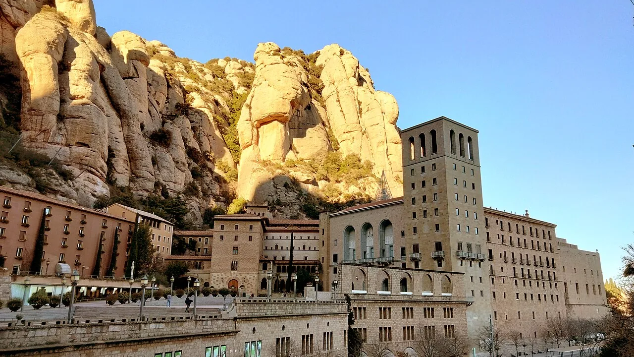 El monasterio de Montserrat al pie de las agujas de roca de la montaña, desde el camino de Sant Miquel.