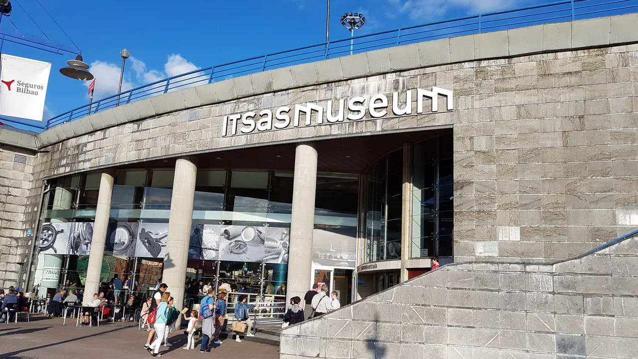 La fachada curva de piedra del Itsasmuseum, con el rótulo del museo sobre la entrada del antiguo astillero.