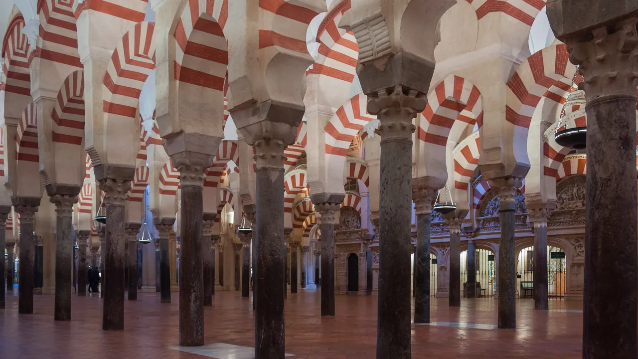 El bosque de columnas y arcos bicolores de la Mezquita-Catedral de Córdoba, alineándose hacia el fondo casi sin gente.