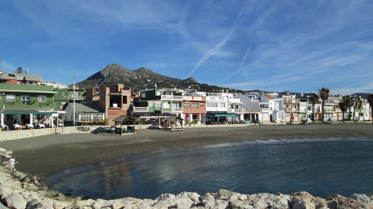 Las casas bajas del antiguo pueblo de pescadores de Pedregalejo dando a la playa, con el monte detrás.